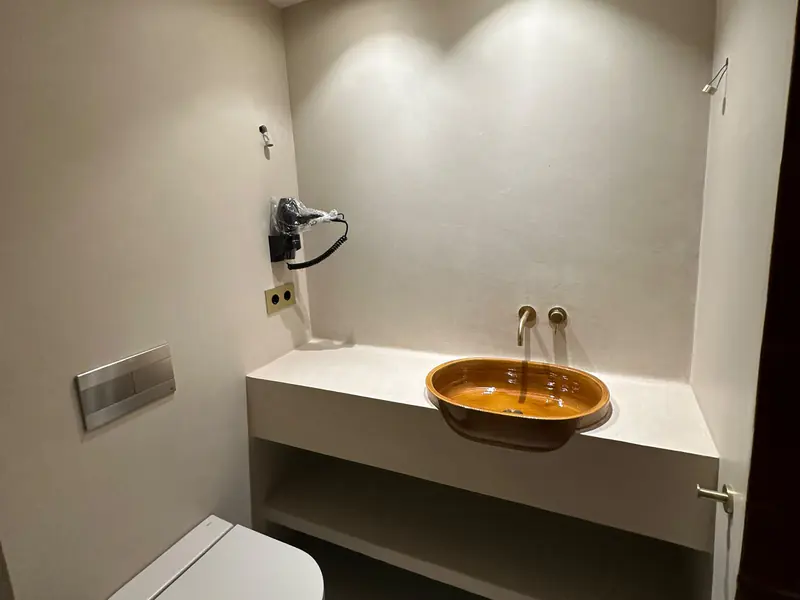 Baño con encimera de obra y paredes de microcemento sellado